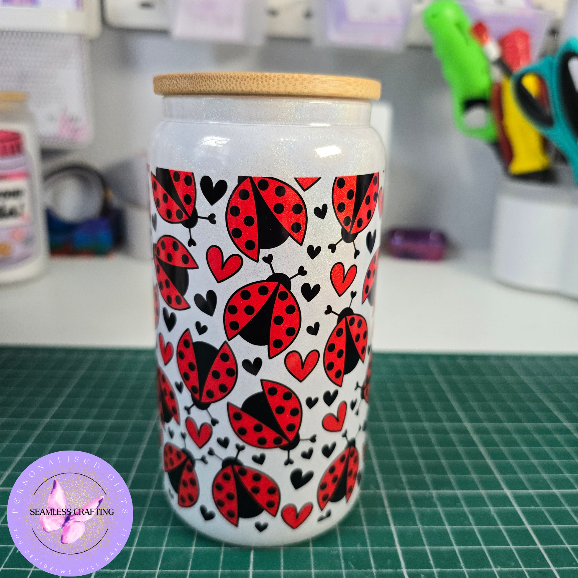 hand holding ladybird glass cup bamboo lid glass straw cute aesthetic drinkware