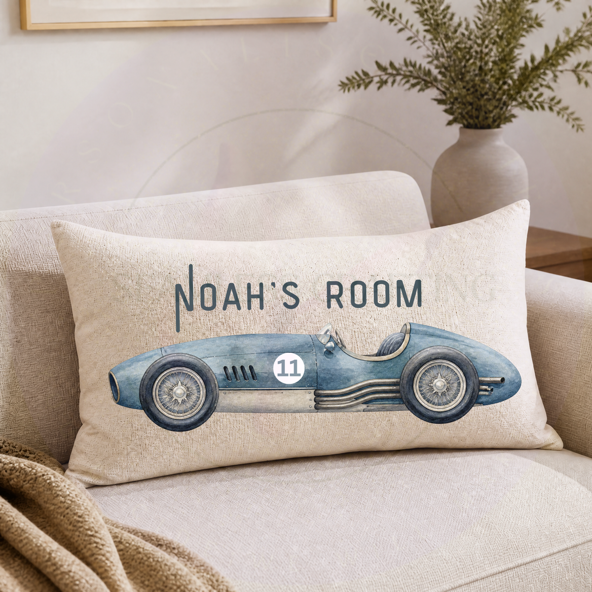 Personalised vintage racing car cushion with blue classic race car and custom name on neutral sofa