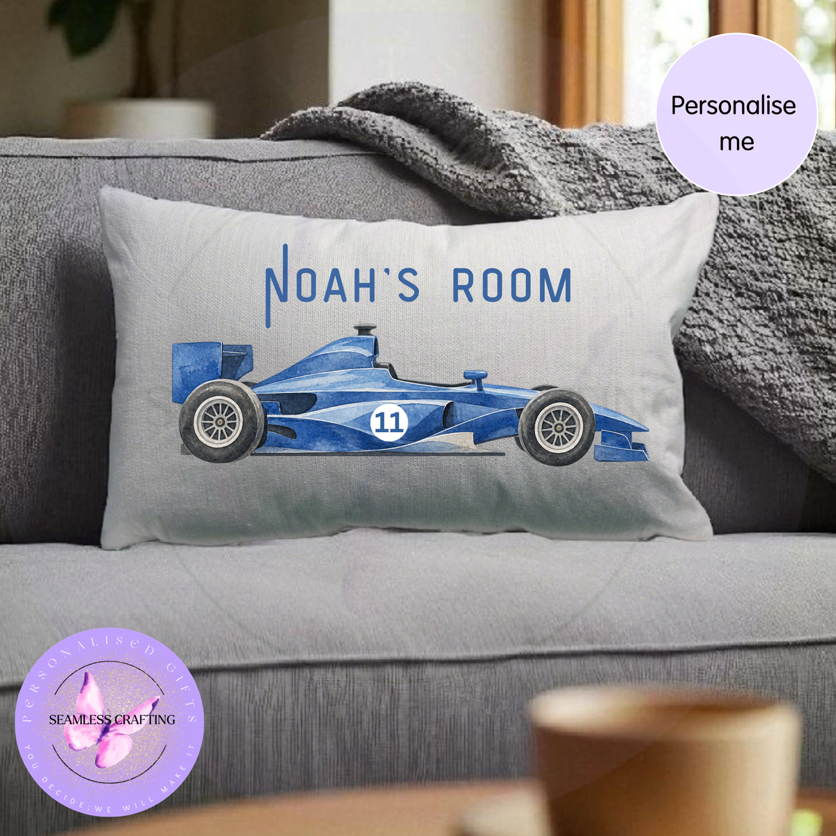 Personalised racing car cushion with blue Formula style race car and custom name on neutral sofa