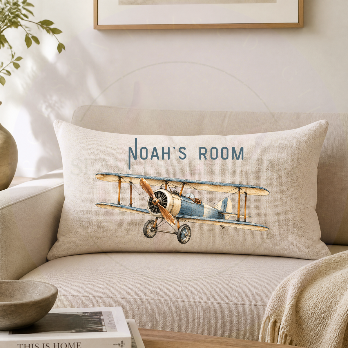 Personalised vintage aircraft cushion with custom Noah's Room wording on neutral sofa