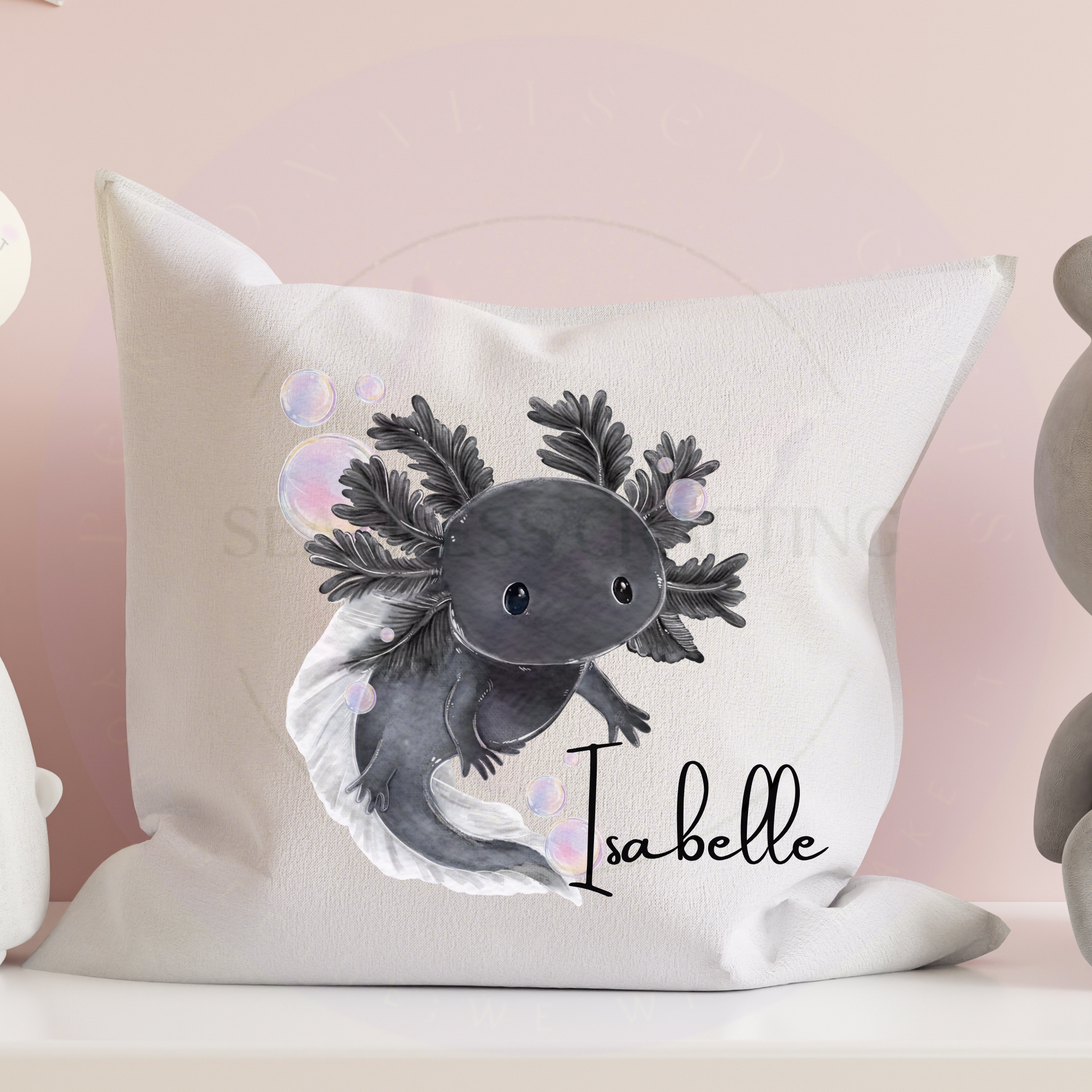 Personalised black axolotl pillow with the name Tom on a white cushion displayed on a sofa