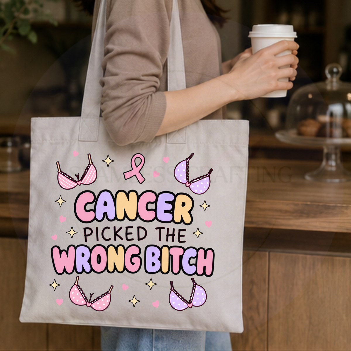 Cancer Picked the Wrong Bitch breast cancer tote bag carried over the shoulder in a café