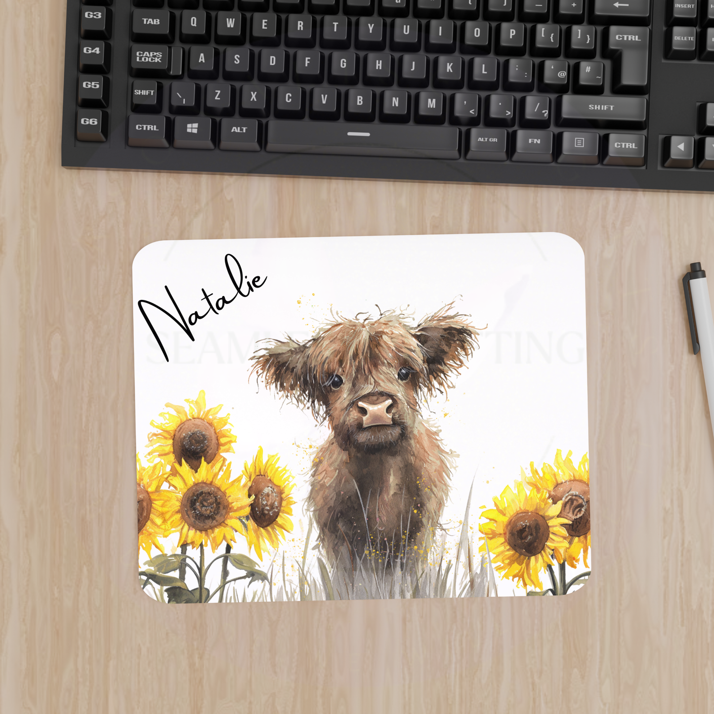 Highland cow personalised mouse mat with sunflowers beside computer keyboard