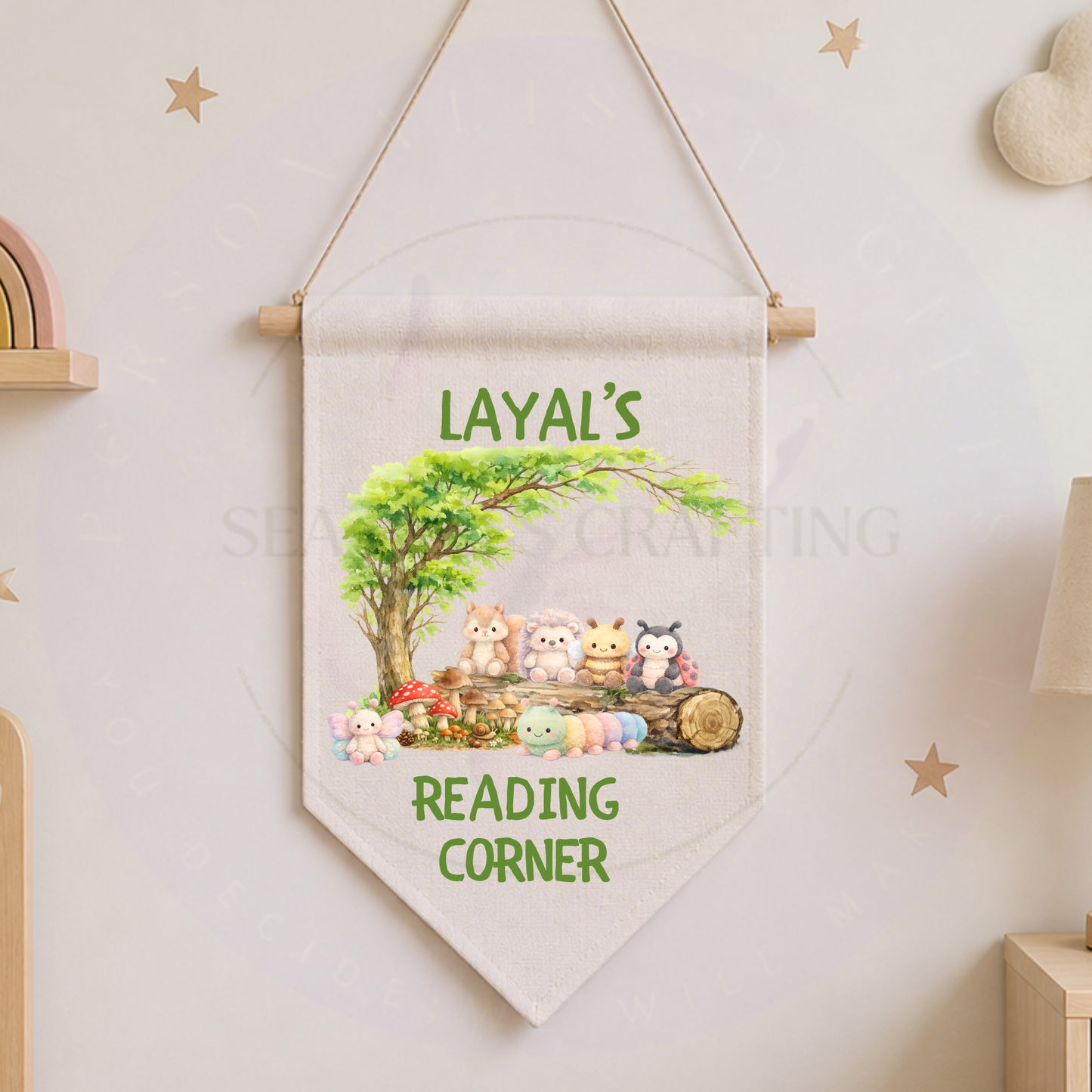 Woodland themed nursery reading nook with cushions, books, and a personalized name banner on the wall.