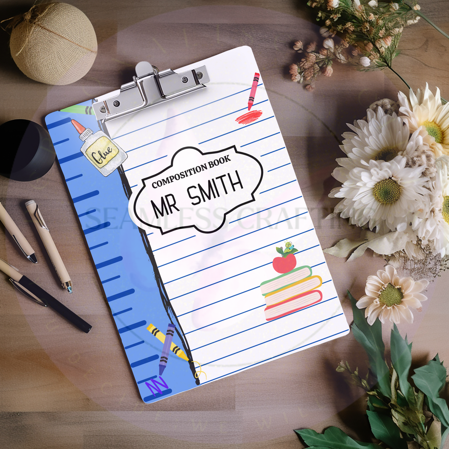 Custom teacher name clipboard on classroom desk with stationery and books