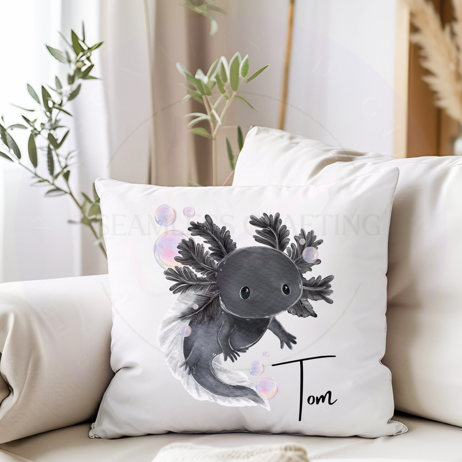Personalised black axolotl cushion with the name Isabelle on a soft white square pillow